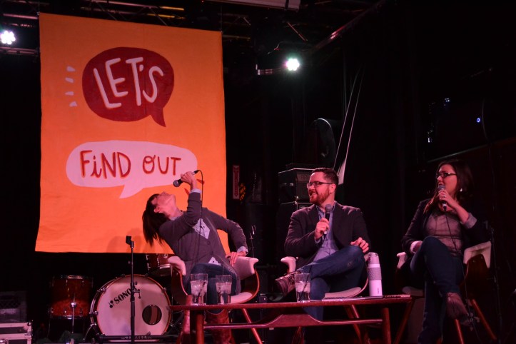 Sarah looks back at the Let's Find Out sign.