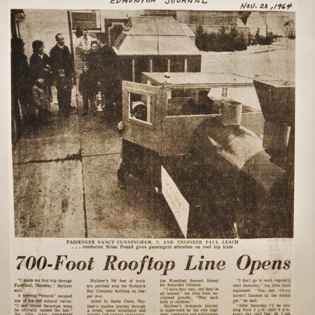 Article headline: 700-Foot Rooftop Line Opens. There's a photograph of people lining up to enter a train on the roof of the Bay.