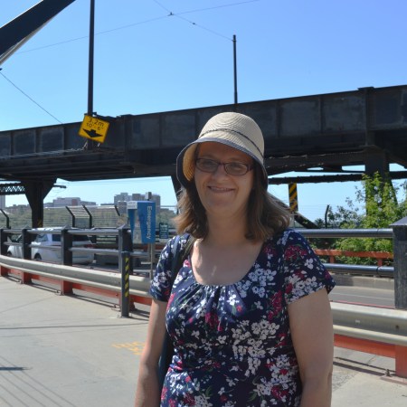 Karen Simonson stands in front of the north side of the High Level Bridge.