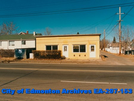 A flat rectangular building overlooks an empty residential street