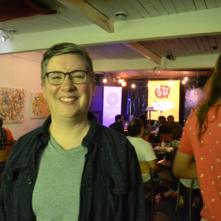 Bryna Andressen smiles at the back of a packed room