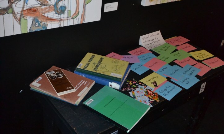 a stack of books about edmonton parks, and a stack of brightly coloured index cards, on a table