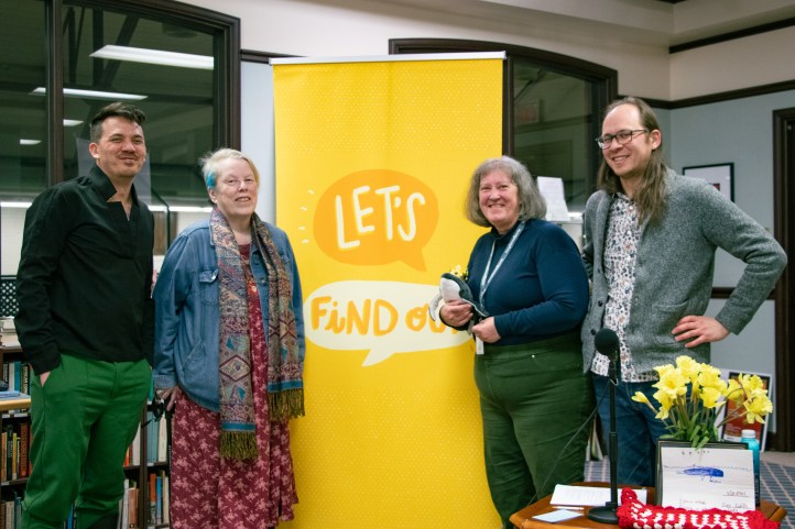 Chris, Candas, Kathryn, and Trevor smile in front of a Let's FInd Out banner